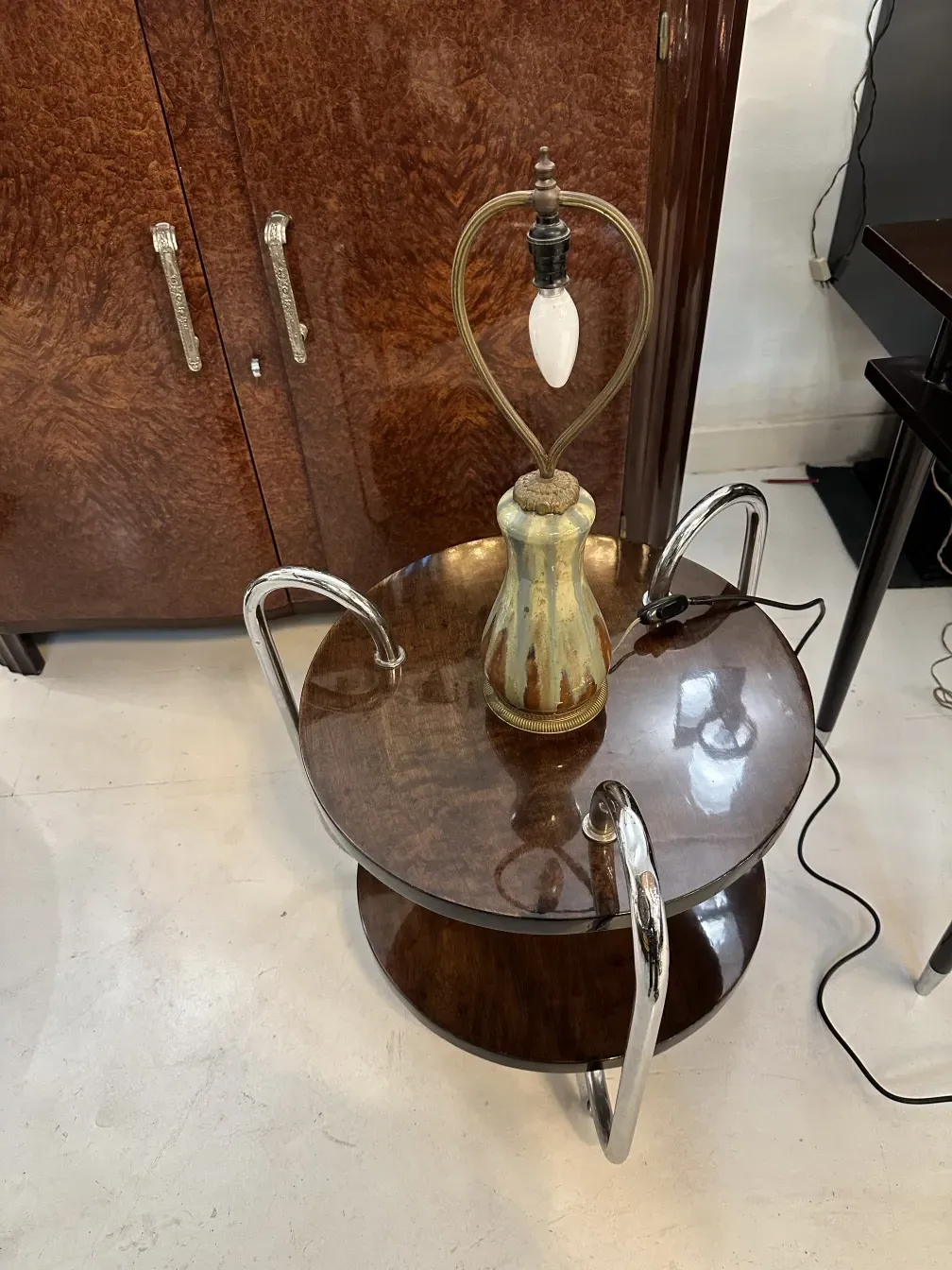 Luminária de mesa antiga com base decorativa e parte de cima de vidro, em um ambiente elegante.