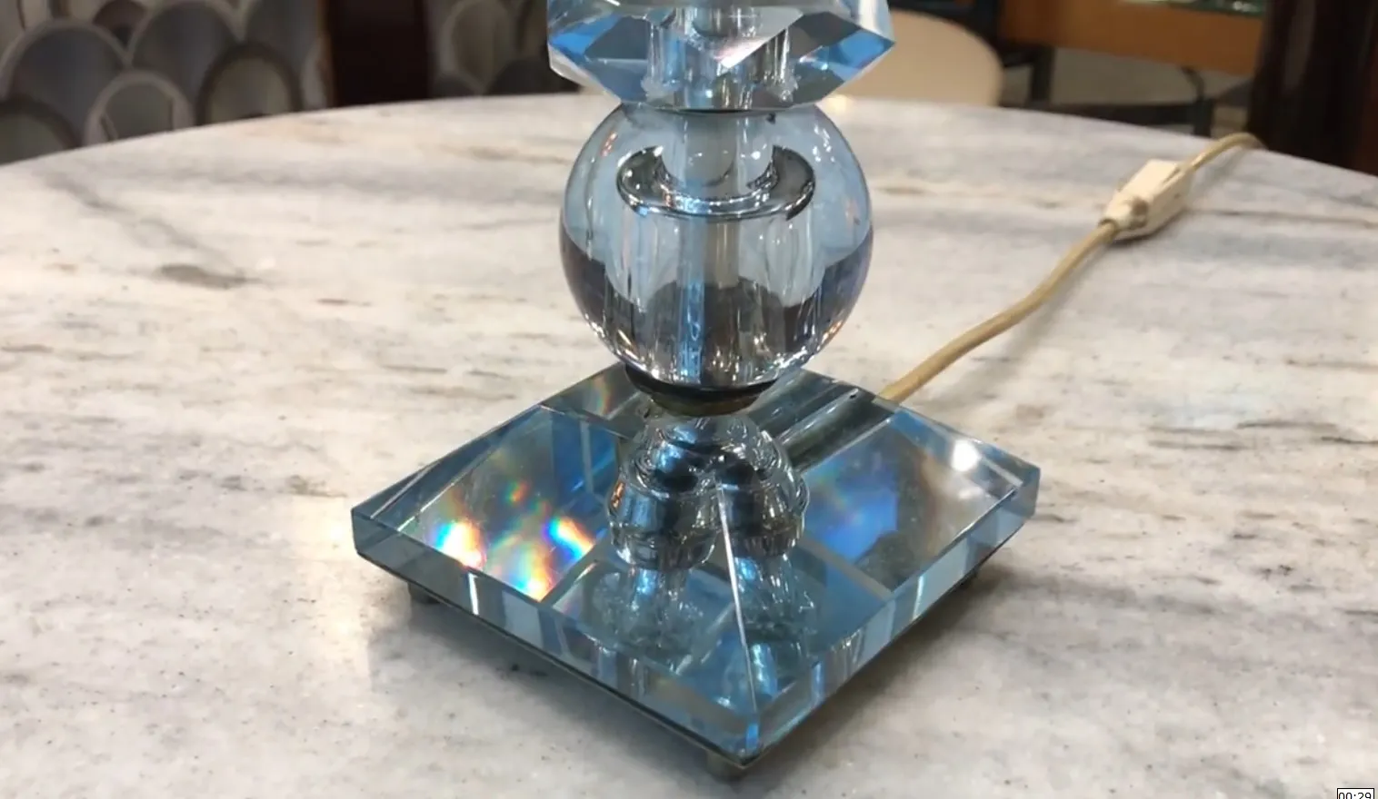 luminária de mesa antiga com detalhes em cristal brilhante e base reflexiva, iluminando um ambiente acolhedor.