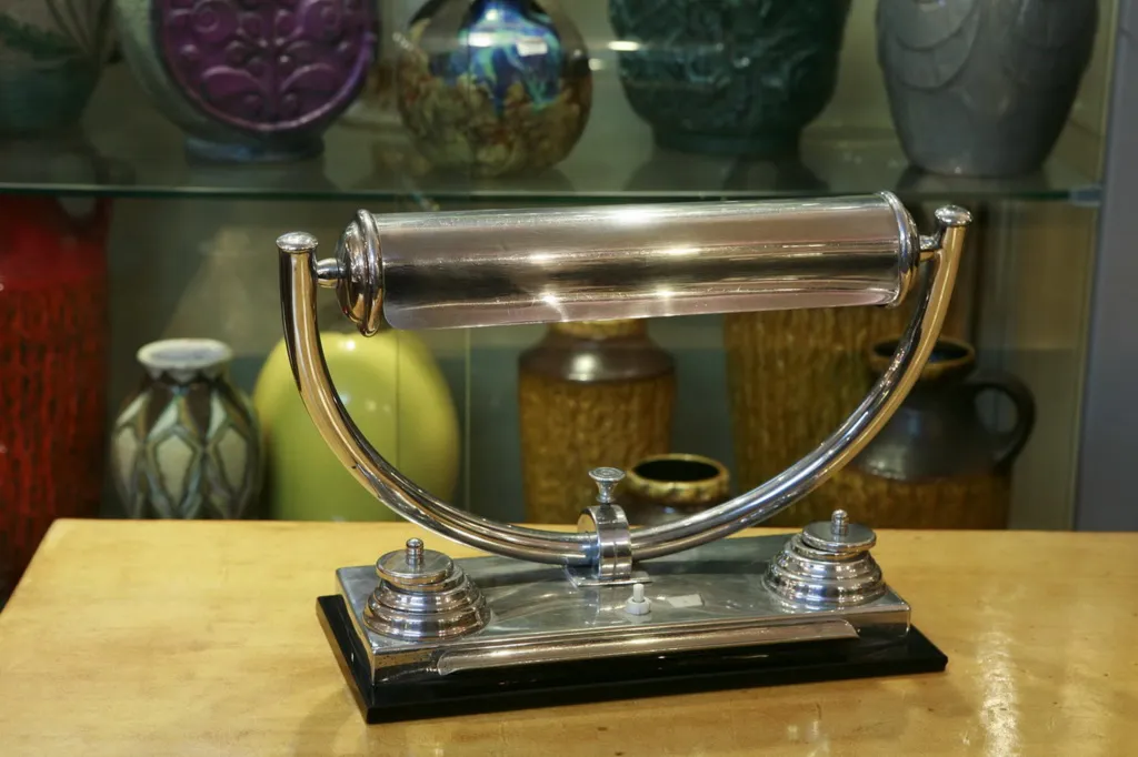 luminária de mesa antiga com formato cilíndrico e base oval