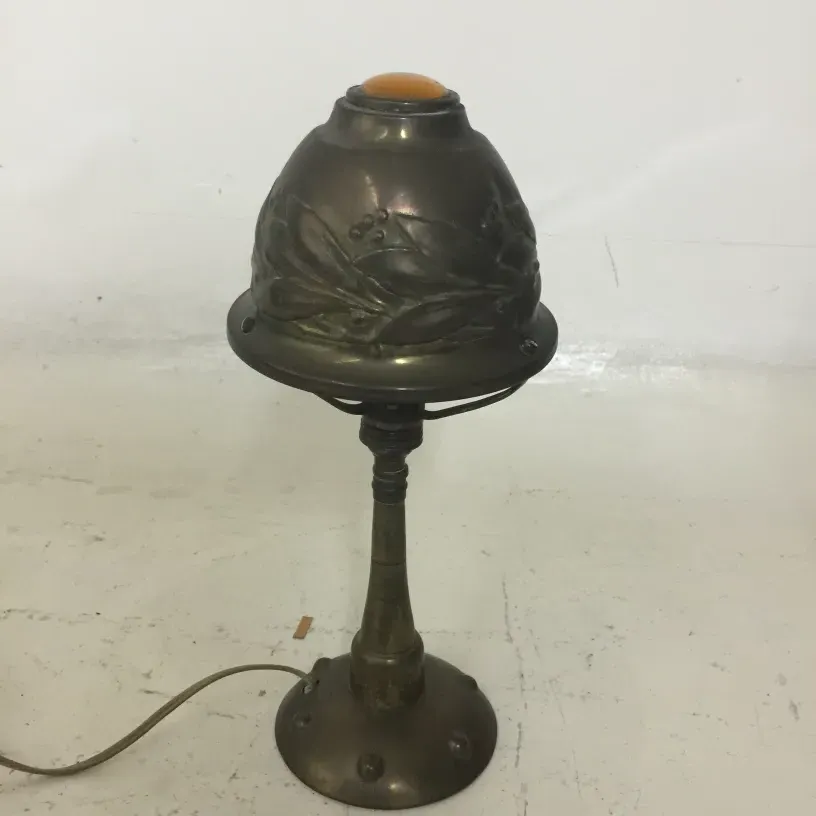 Luminária de mesa antiga com base e sombra decoradas.