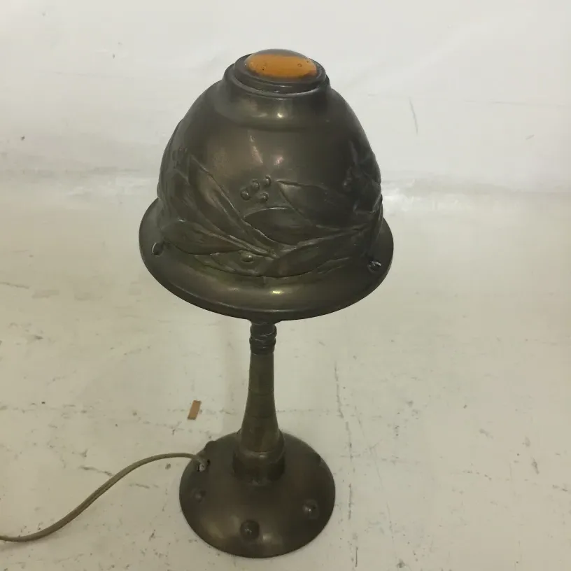 luminária de mesa antiga com detalhes decorativos na cúpula e fundo branco