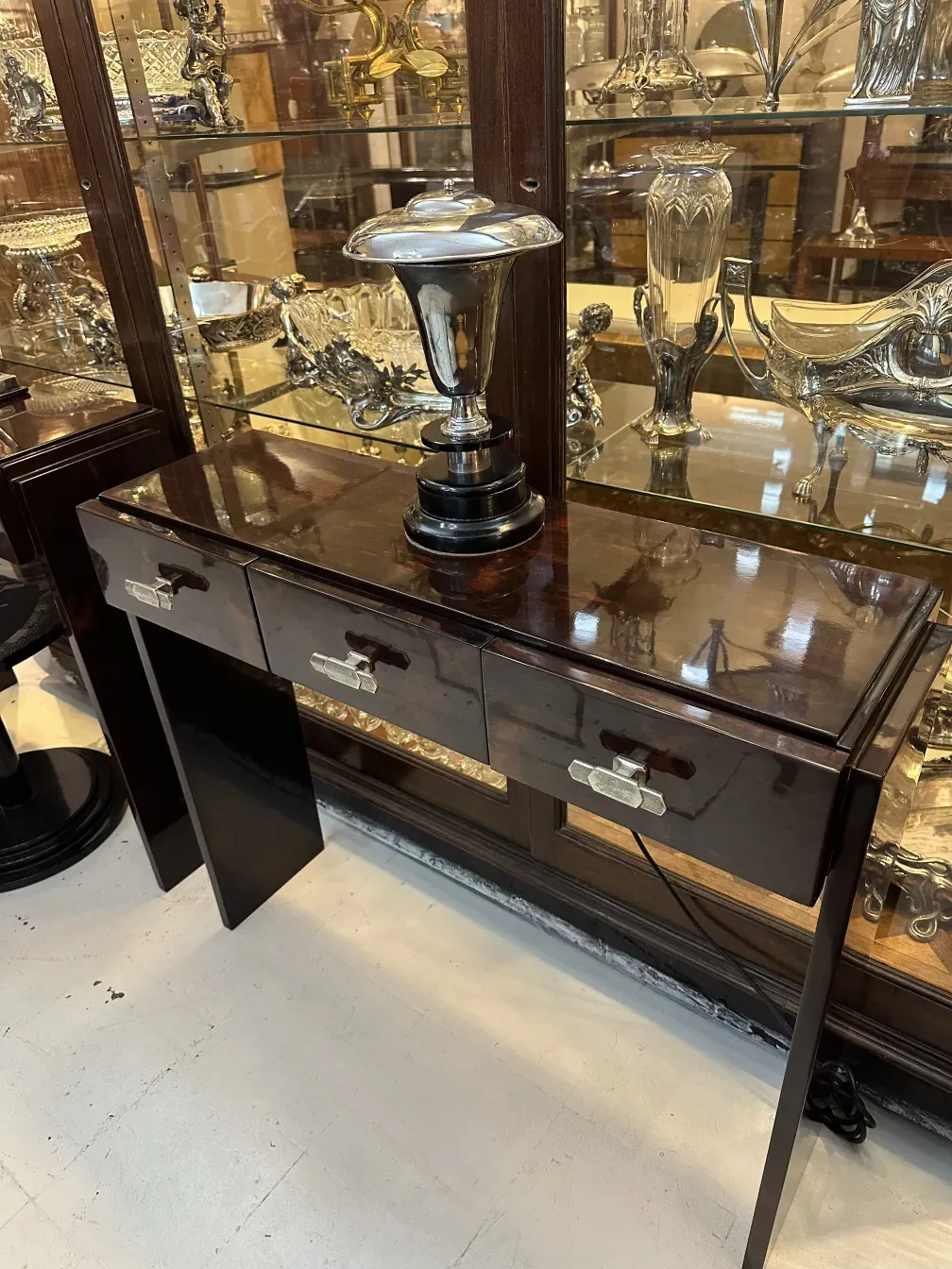 luminária de mesa antiga com design elegante, cercada por várias antiguidades