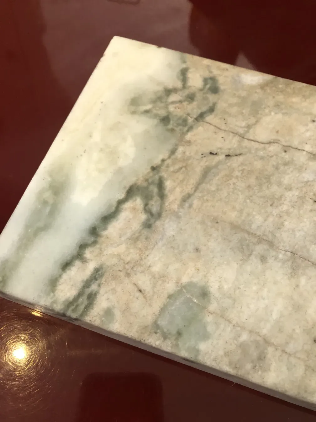 Antiga luminária de mesa com base decorativa e detalhes verdes, ambiente aconchegante