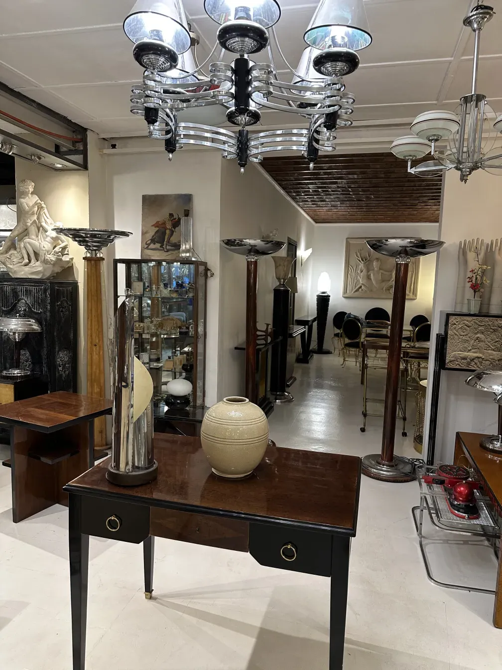 Luminária de mesa antiga com base preta e detalhes decorativos em um ambiente clássico.