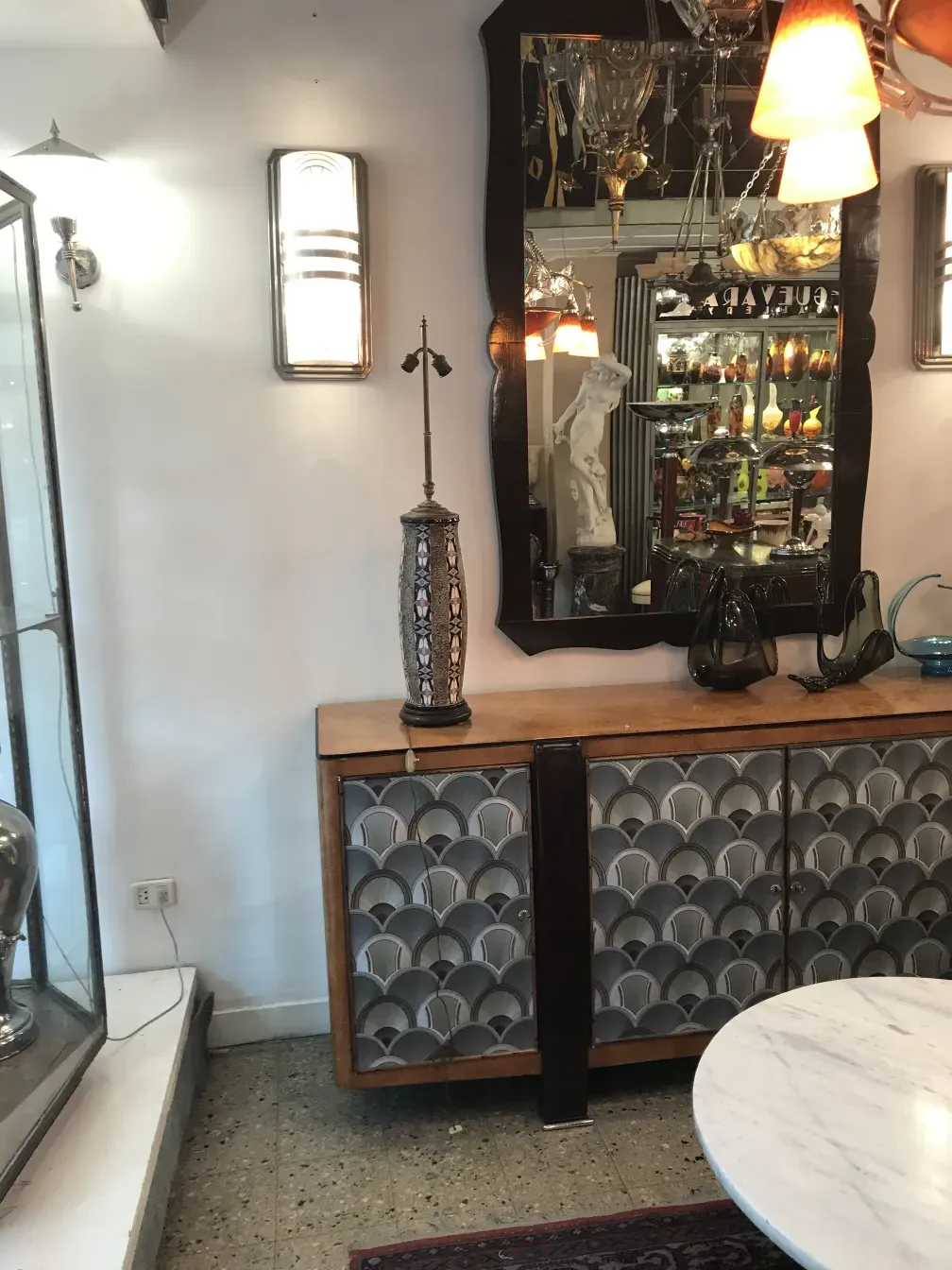 Antiga luminária de mesa com design decorativo em um ambiente clássico com móveis antigos.