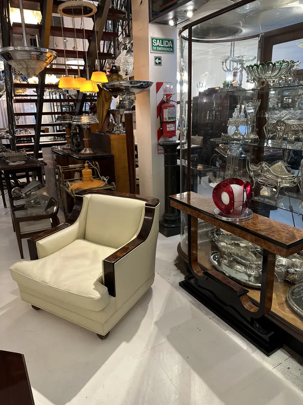 luminária de mesa antiga colocada em uma mesa de madeira em um ambiente decorativo cercada por elegantes antiguidades e iluminação suave