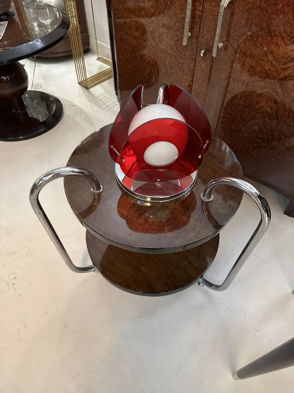 Luminária de mesa antiga com detalhes em vermelho sobre uma mesa