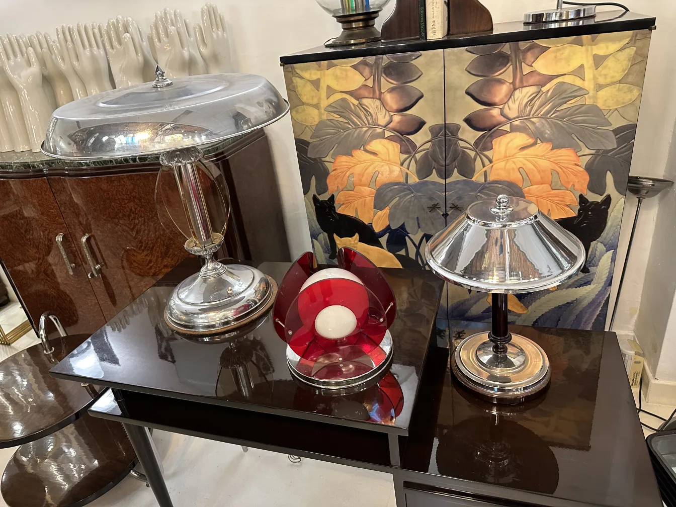 Luminária de mesa antiga com base metálica e cúpula brilhante, realçando um ambiente acolhedor.