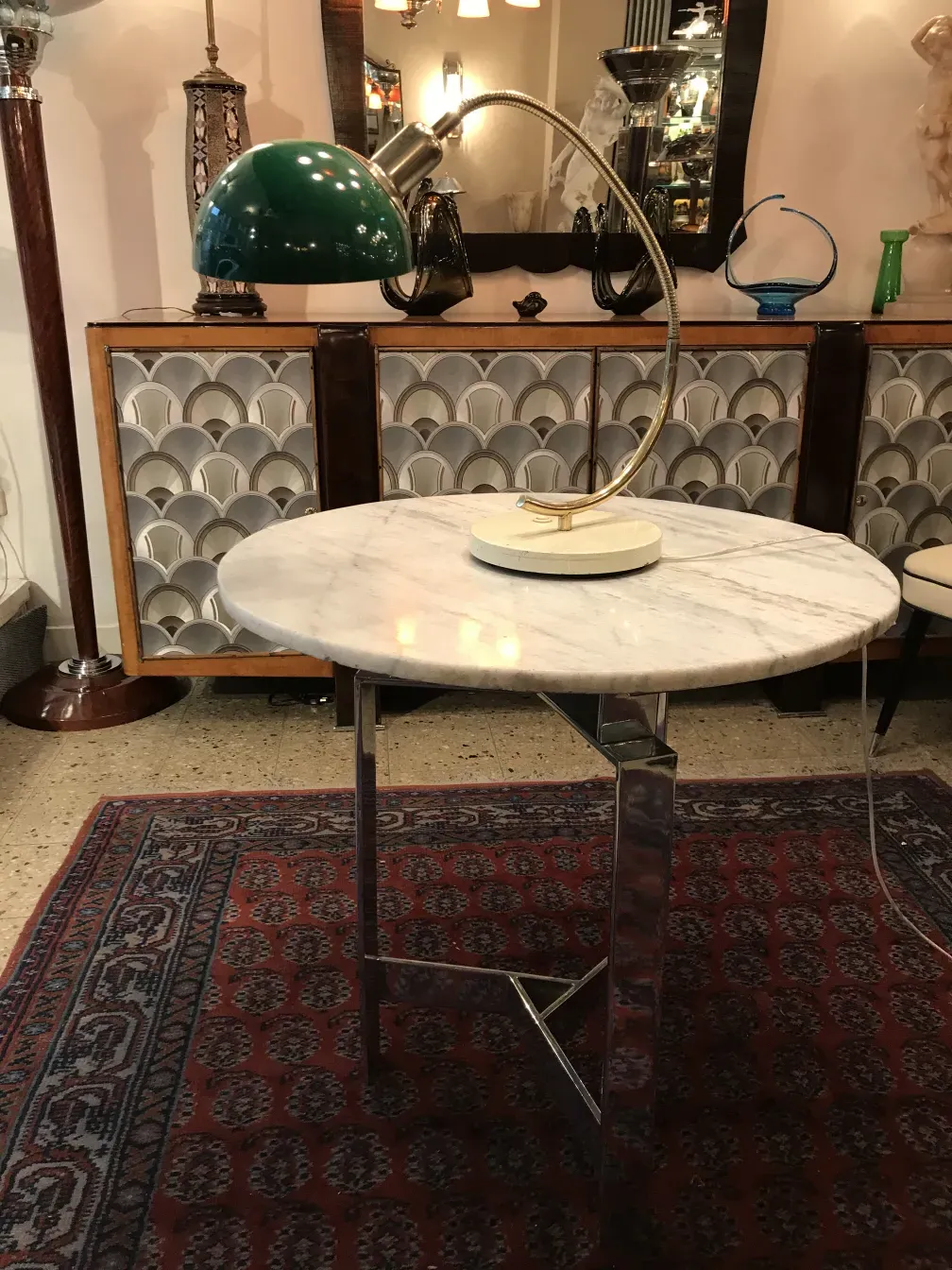 Luminária de mesa antiga com base redonda e braço flexível em um ambiente vintage com tapete oriental.