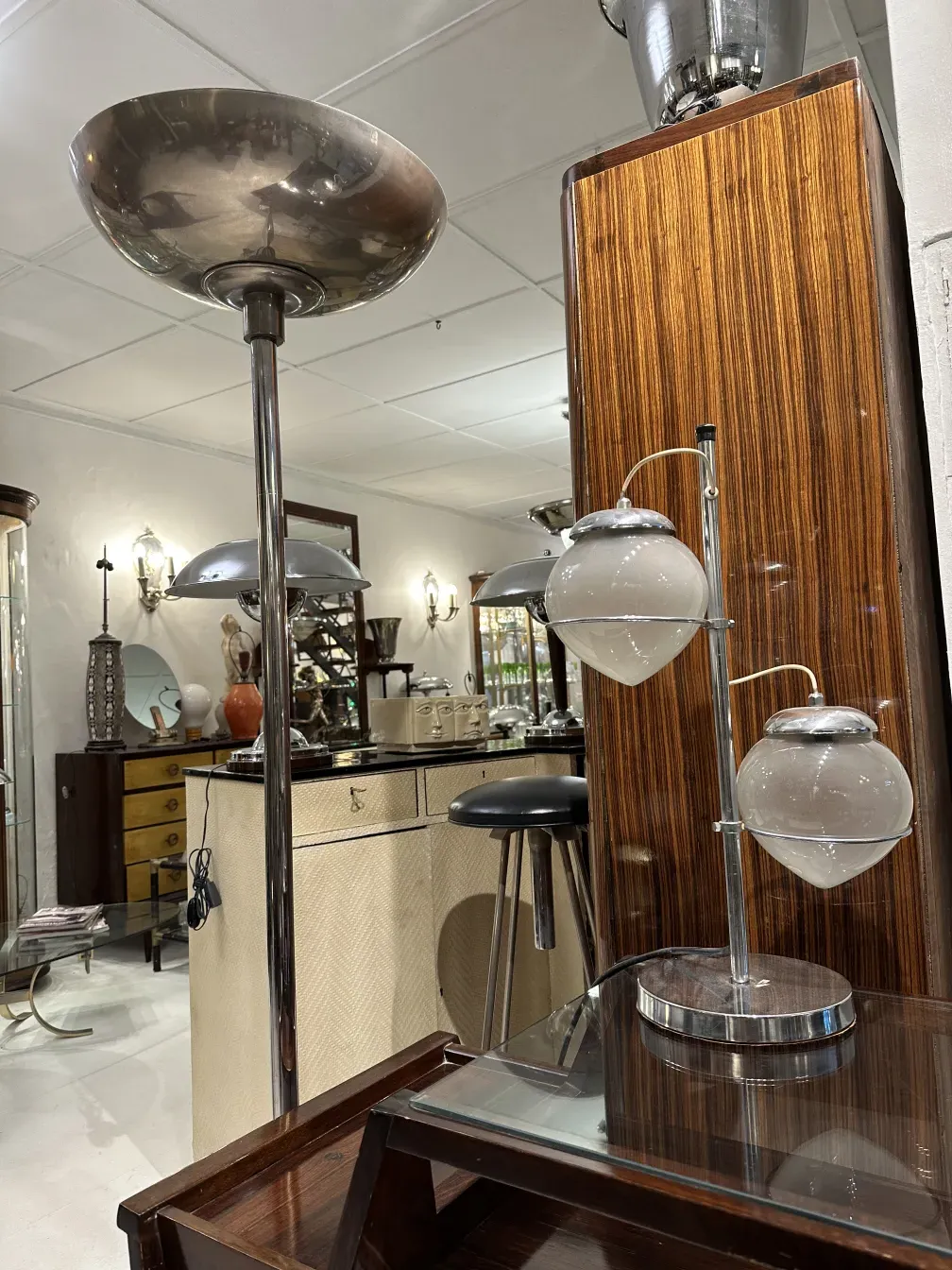 Antiga luminária de mesa com base moderna e cúpulas de vidro, em um ambiente elegante com móveis vintage.