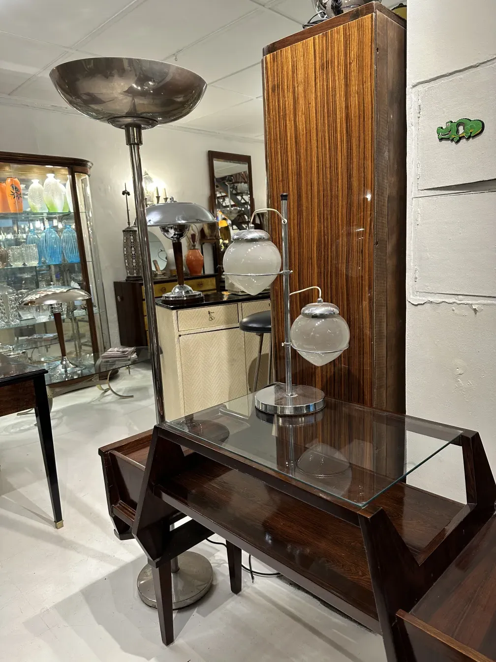 luminária de mesa antiga com base cromada e vidro esférico em um ambiente elegante