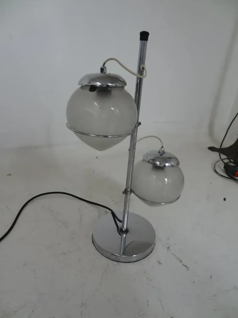 Luminária de mesa antiga com duas esferas em um fundo claro