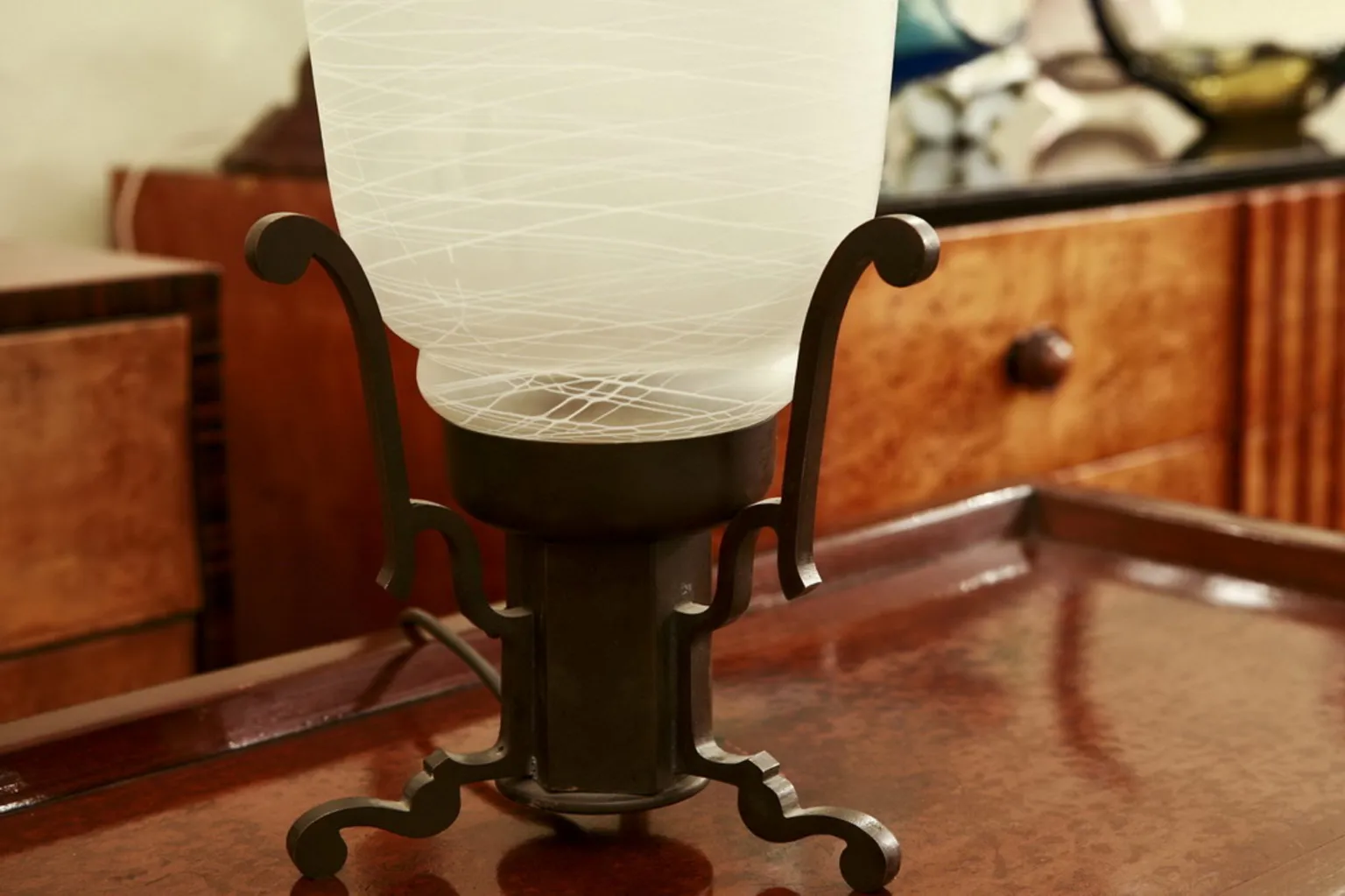 Antiga luminária de mesa com base decorativa em um ambiente aconchegante.