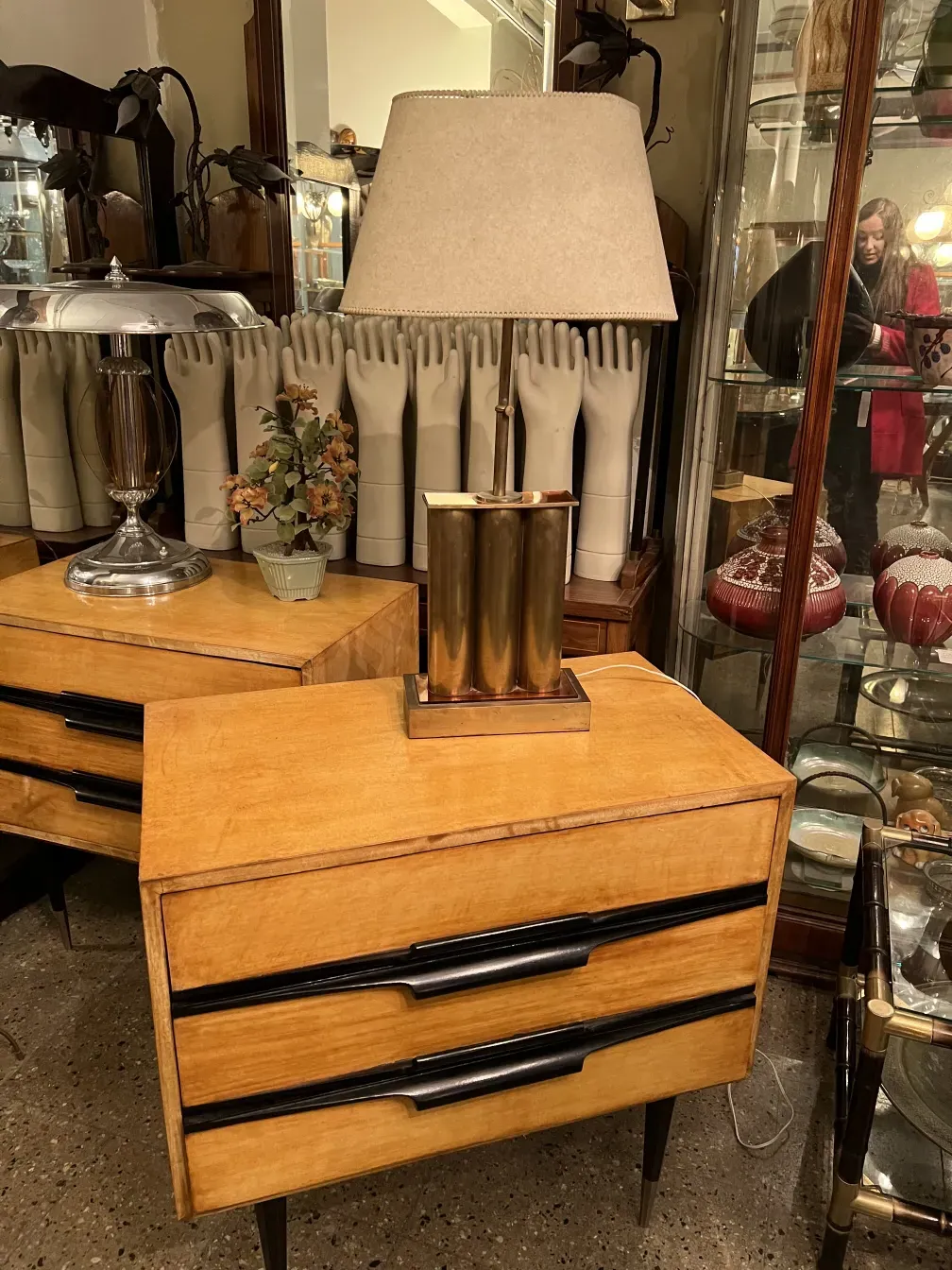 Luminária de mesa antiga com uma cúpula elegante e elementos decorativos ao fundo.