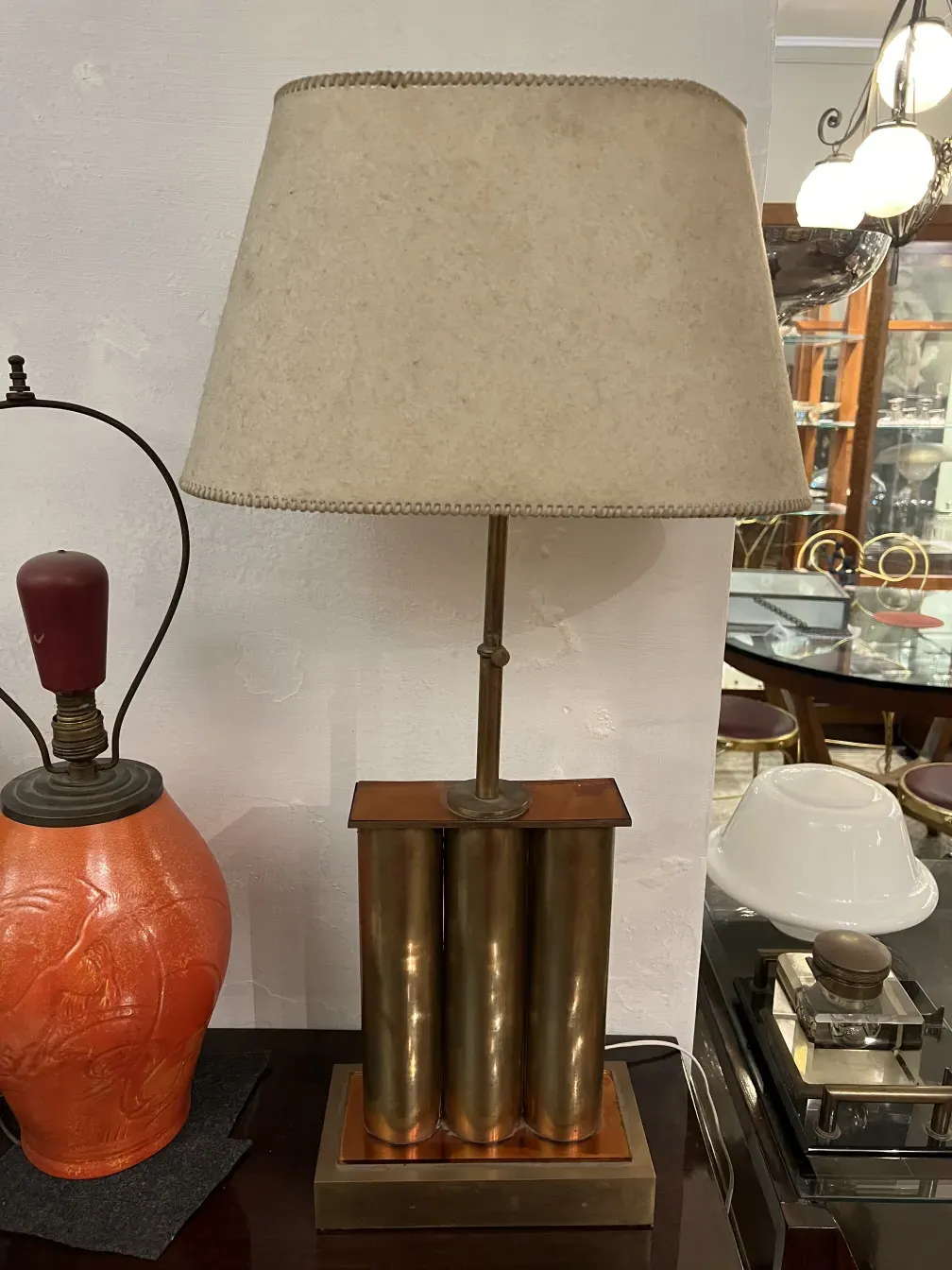 Luminária de mesa antiga com base elegante e tampa bege, em um ambiente clássico.