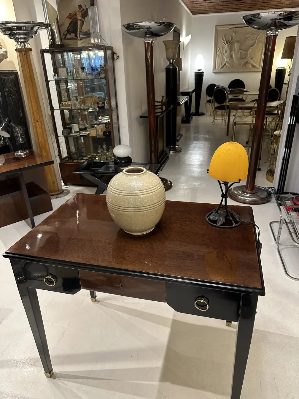 Antiga luminária de mesa amarela em um ambiente acolhedor com objetos decorativos.