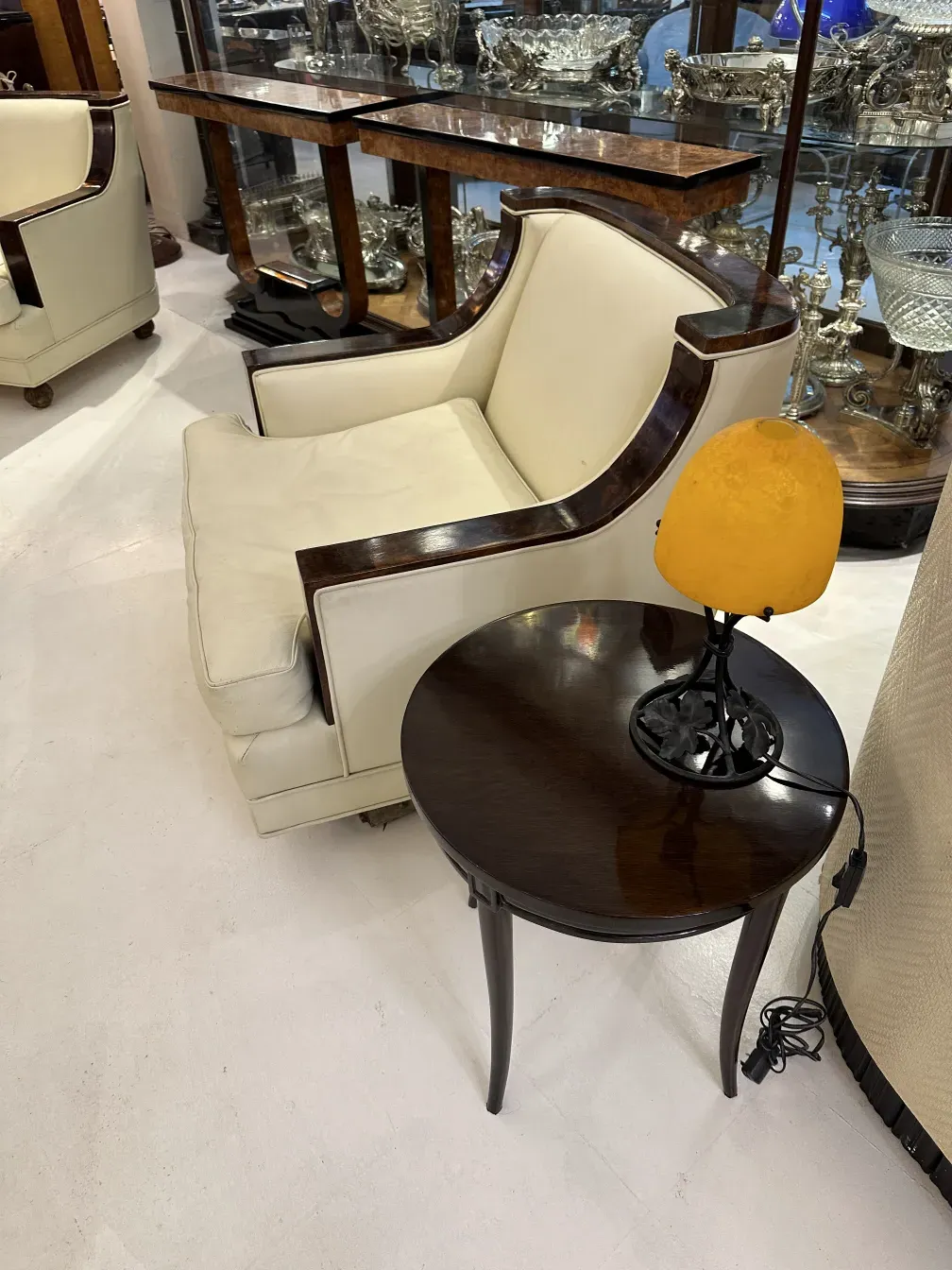 Luminária de mesa antiga com abajur redondo em mesa de madeira, ambiente elegante.