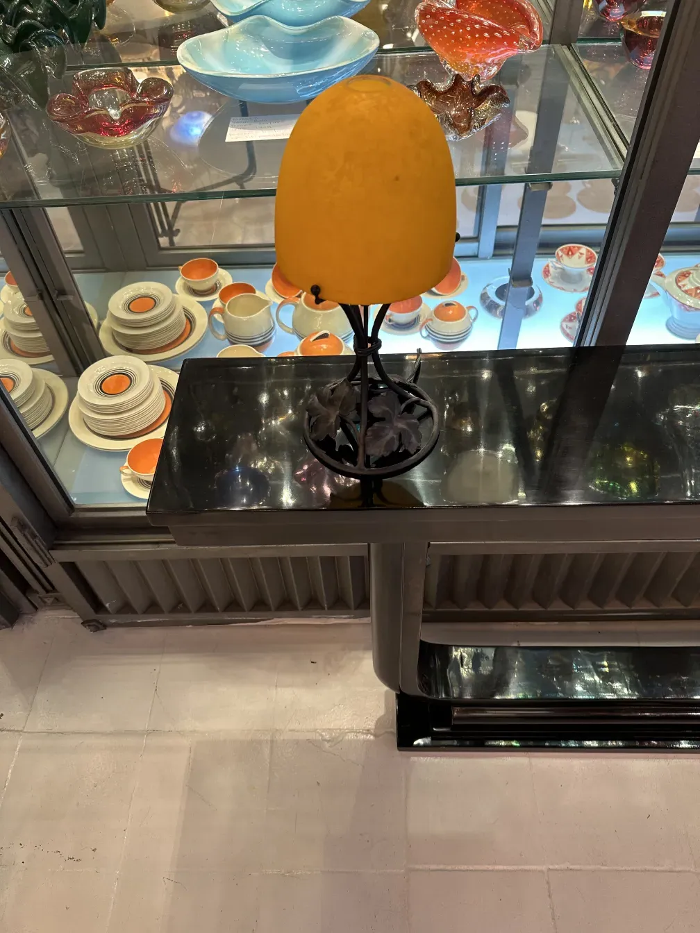 Luminária de mesa antiga com abajur amarelo em ambiente de exibição