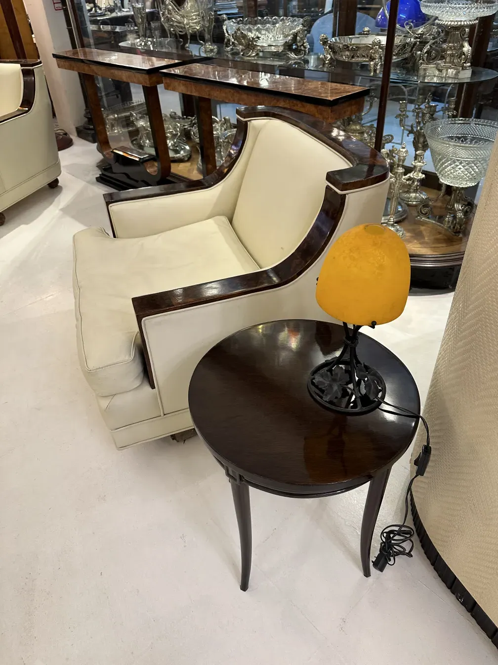 Luminária de mesa antiga com base preta e abajur amarelo, iluminação suave em um ambiente elegante.