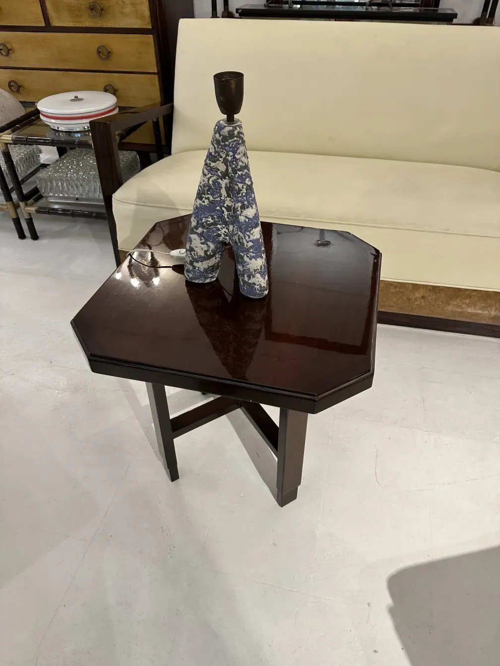 luminária de mesa antiga com base decorativa e design colorido, ao lado de um sofá claro
