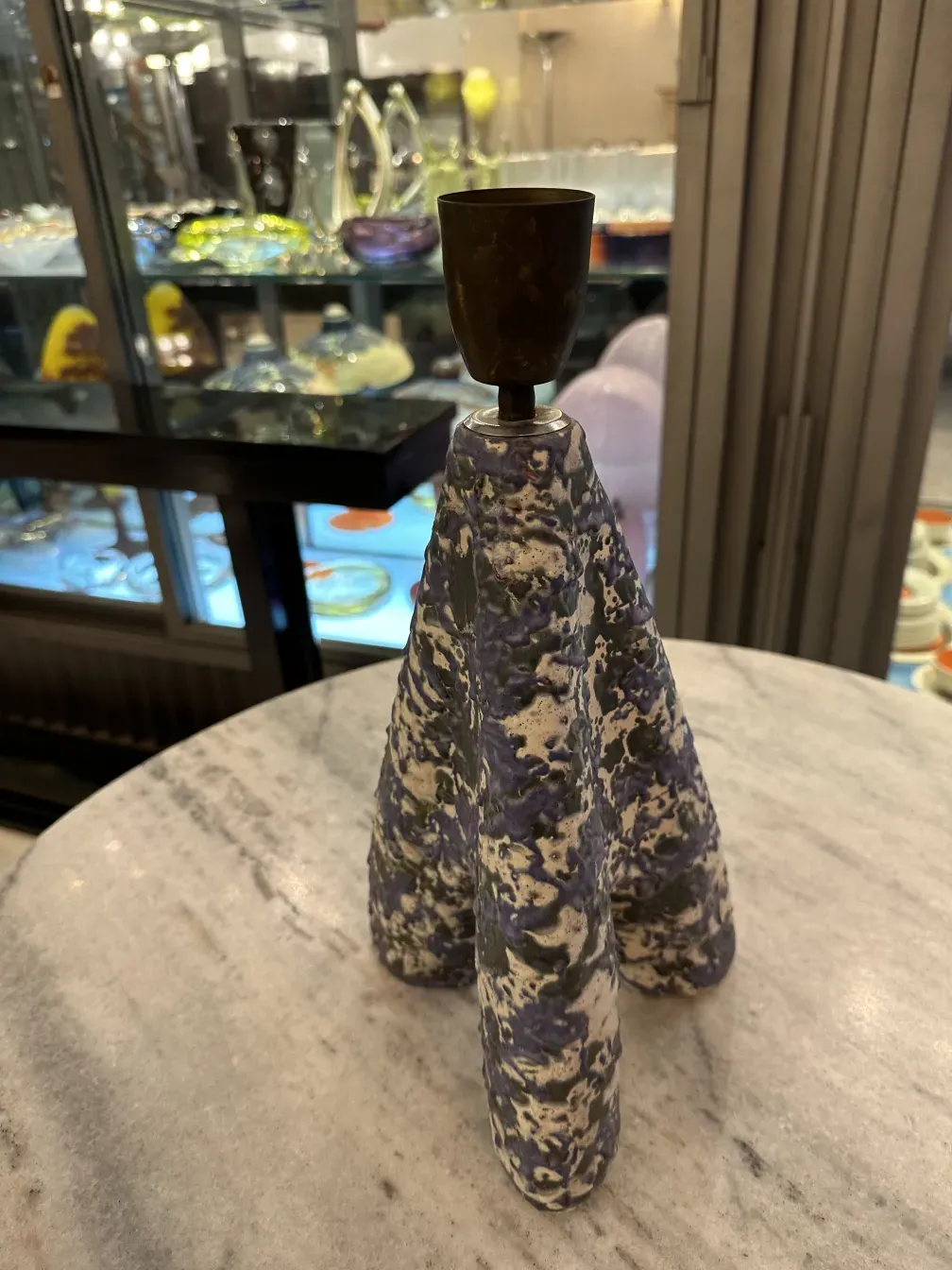 antiga luminária de mesa com design exclusivo em tons de roxo sobre uma mesa de mármore