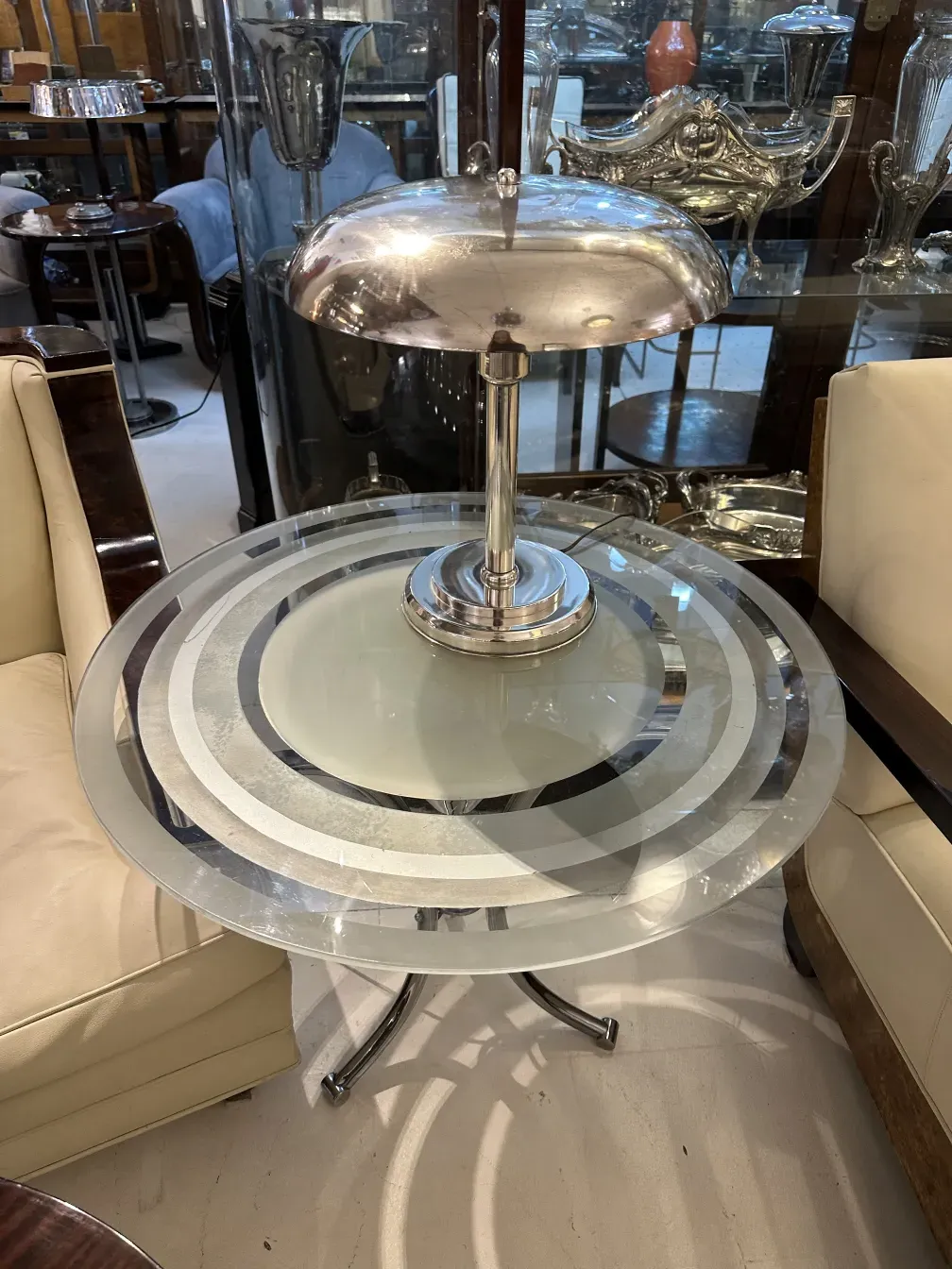 Luminária de mesa antiga com base prateada e cúpula redonda, atmosfera elegante.