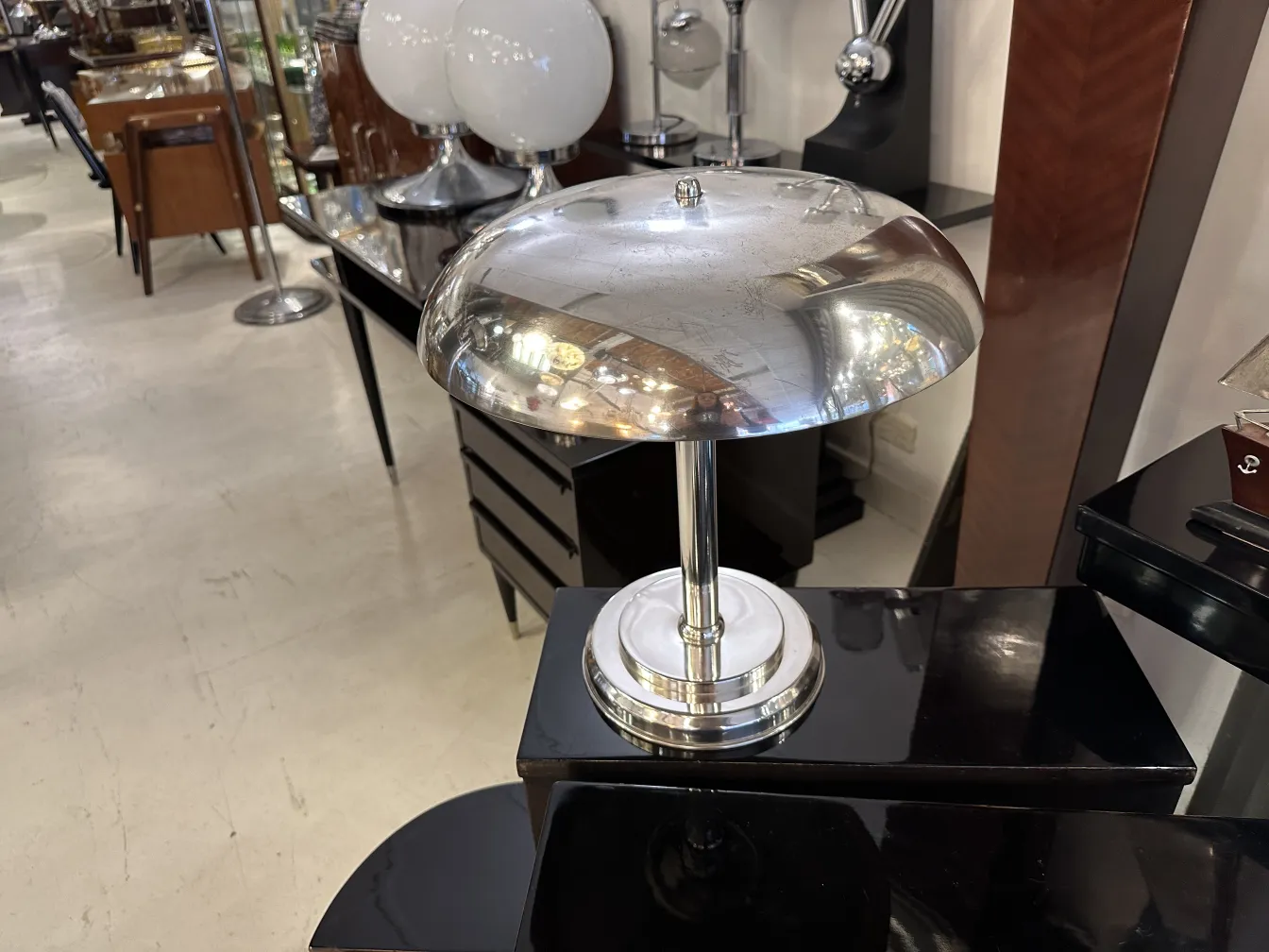 Luminária de mesa antiga com base brilhante e design elegante, em um ambiente aconchegante.