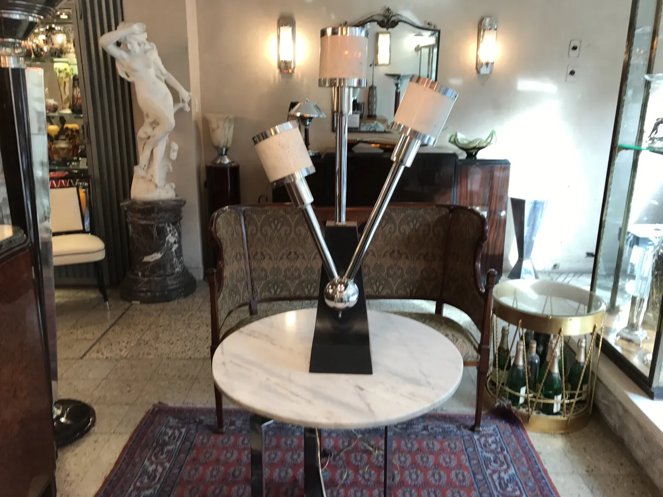 Luminária de mesa antiga com três braços e abas. Fundo decorado.