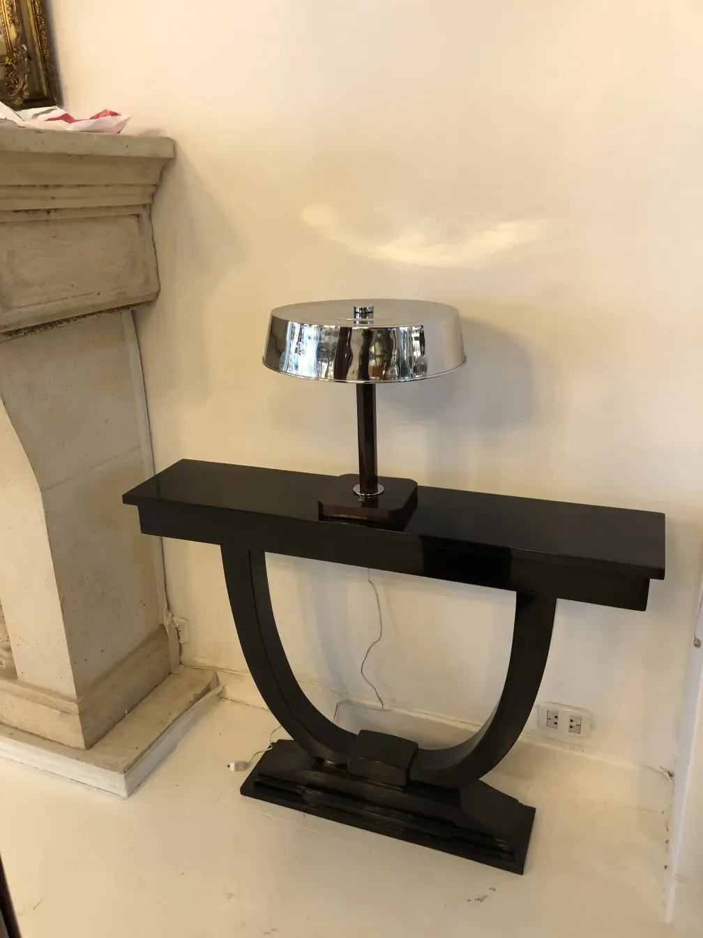 luminária de mesa antiga com base preta e cúpula cromada, em um ambiente clássico