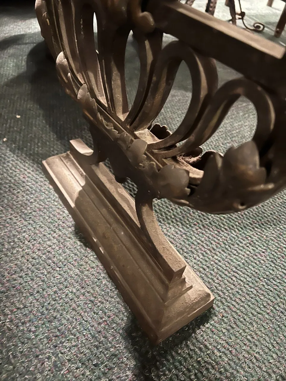 Side view of an antique decorative console with intricate details.