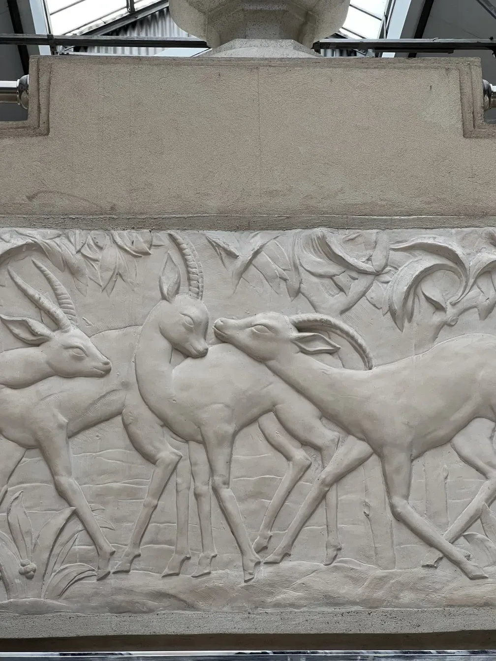 Antique console featuring deer relief in a classic setting.