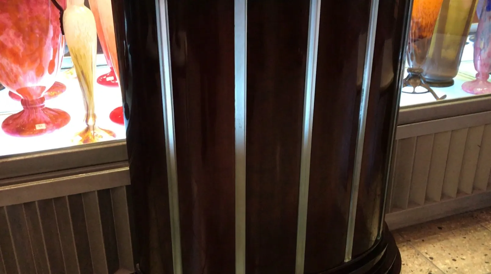 Antique decorative console in a vintage setting with colorful glass items.