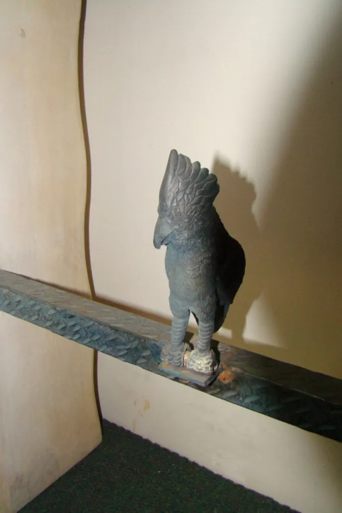 antique console featuring a bird figure on top