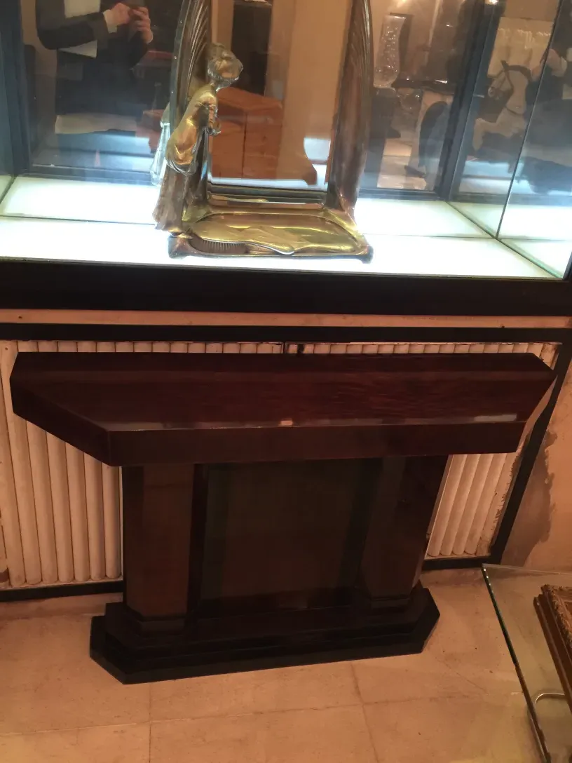 Antique console storage furniture with glass, elegant and classic. Features a bright background with decorative items.