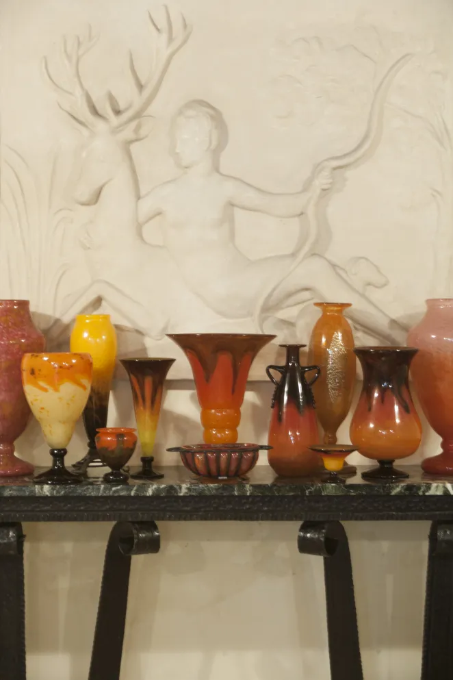antique console decorated with colorful vases and light background
