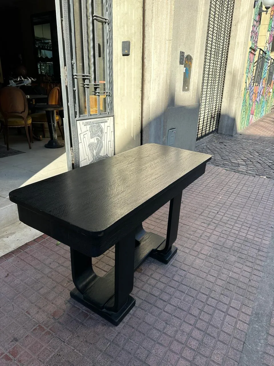 Side view of an antique black console on the sidewalk