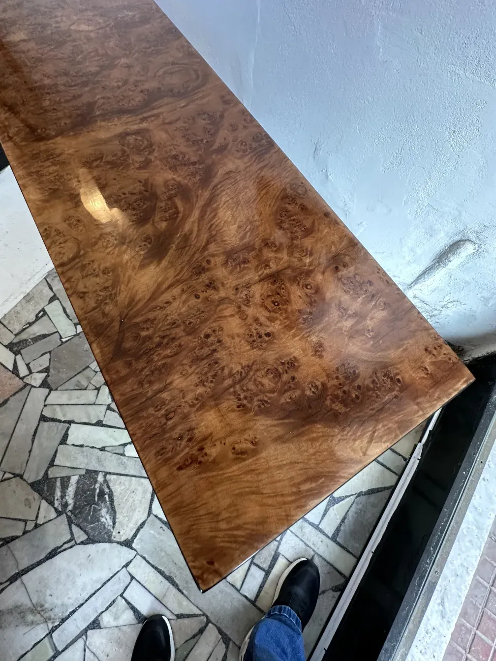 Three antique consoles with glossy surfaces and unique patterns, in an elegant setting.