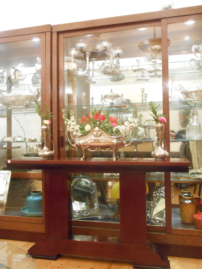 Three antique consoles displayed elegantly, decorated with flowers.