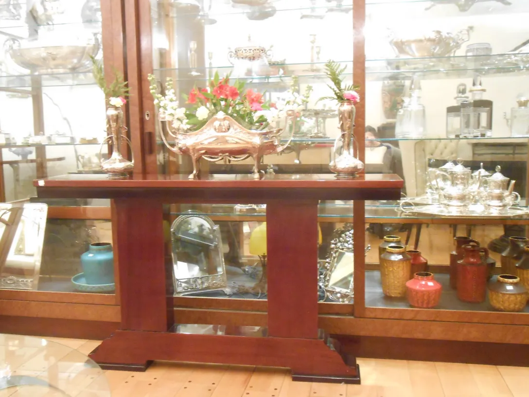 three antique consoles with floral arrangement and artifacts