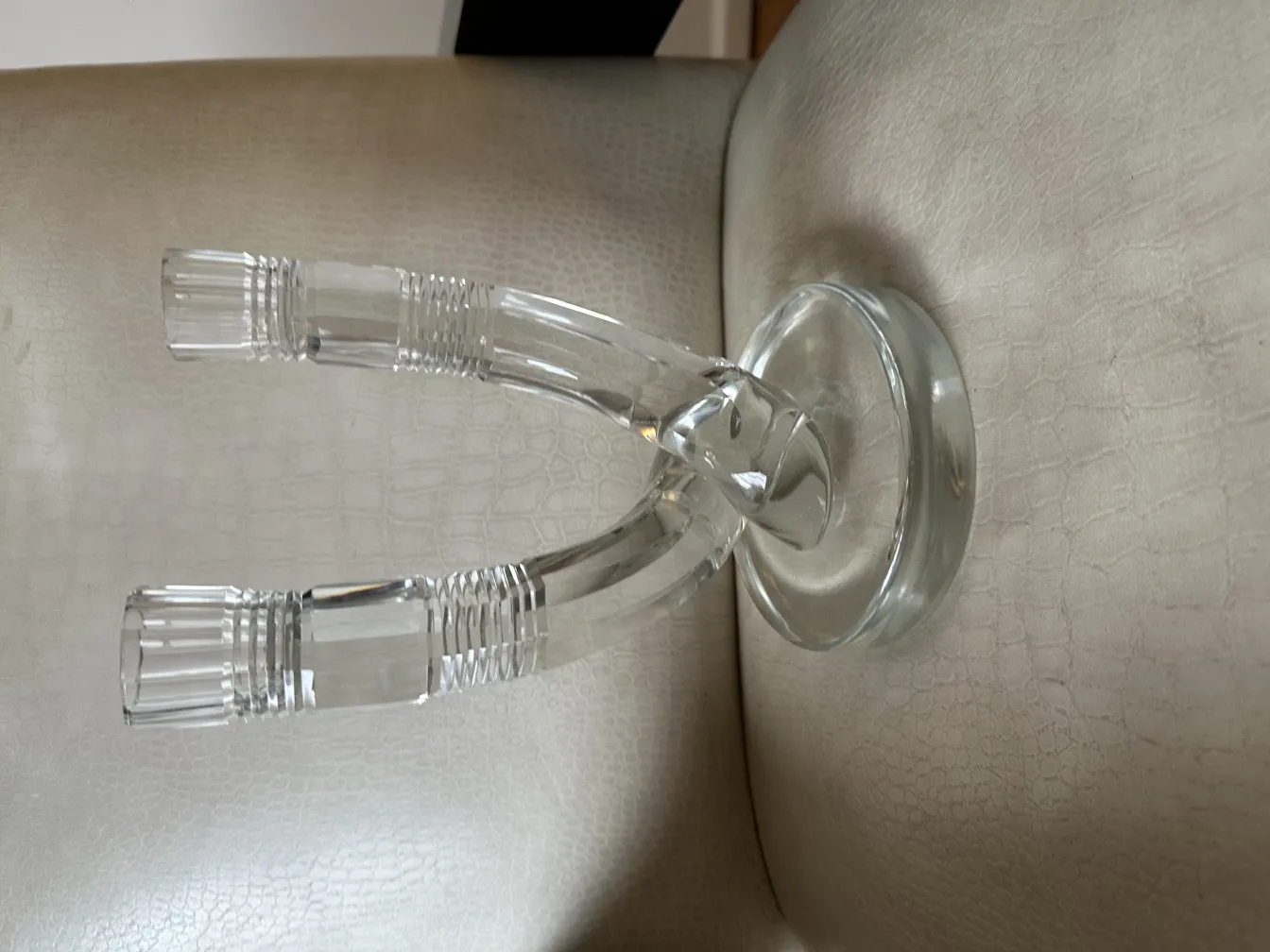 Antique transparent candelabra on a soft surface, elegant in design.