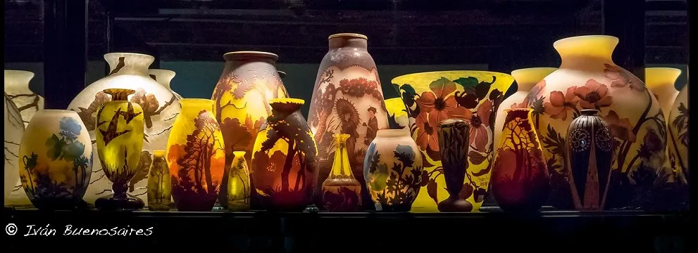 Coleção de antiguidades com vidros assinados de Muller Fres, diversas cores e formas.