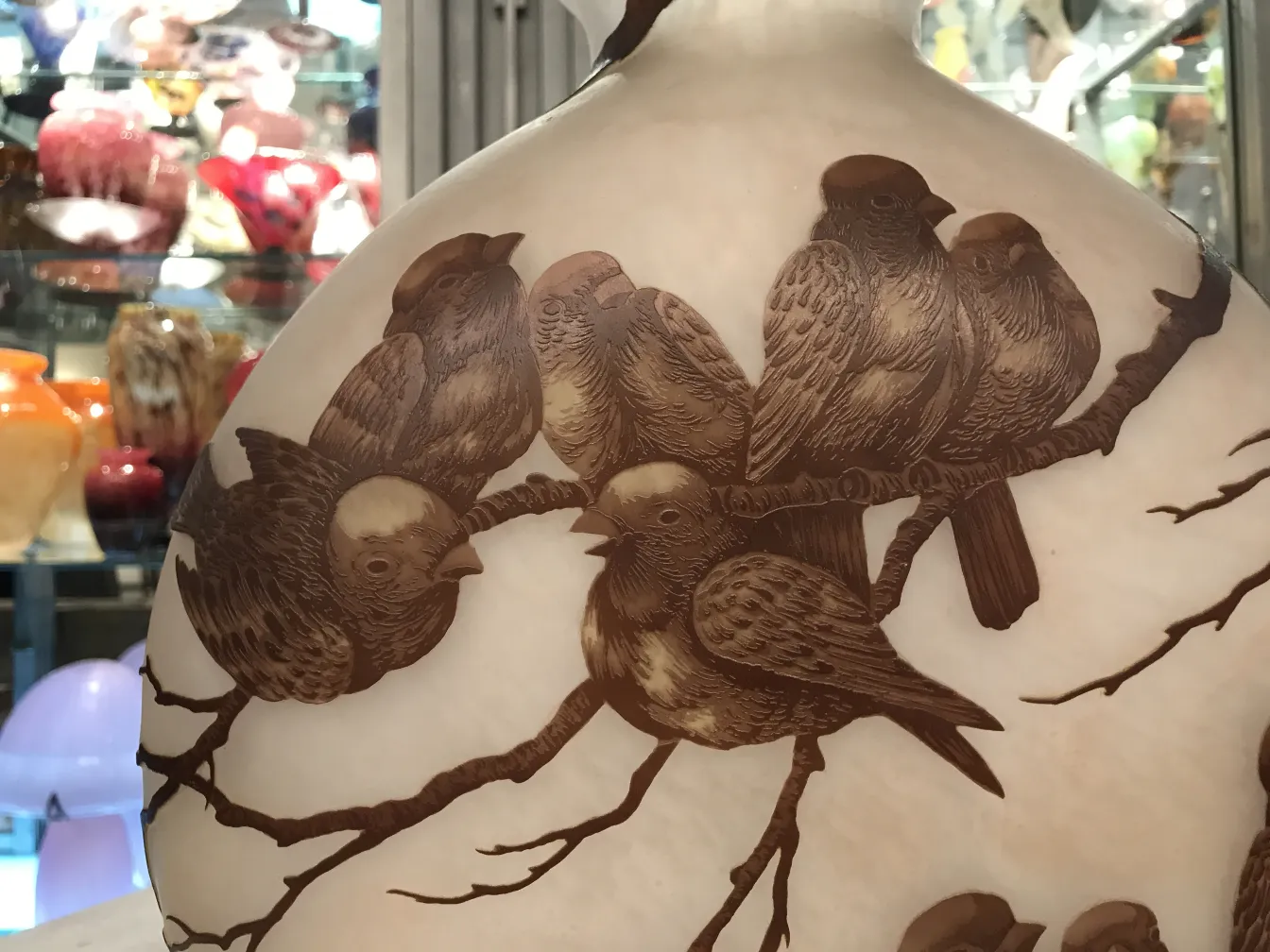 Vidro antigo assinado Muller Fres com aves decorando o objeto.