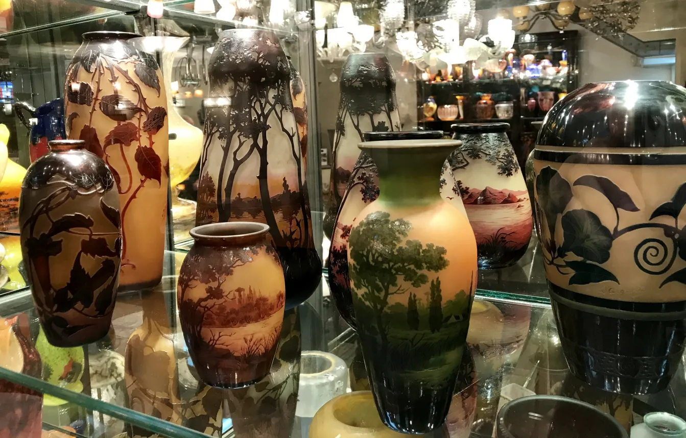 Vidro assinado por Muller Fres em uma vitrine, com paisagens e detalhes.