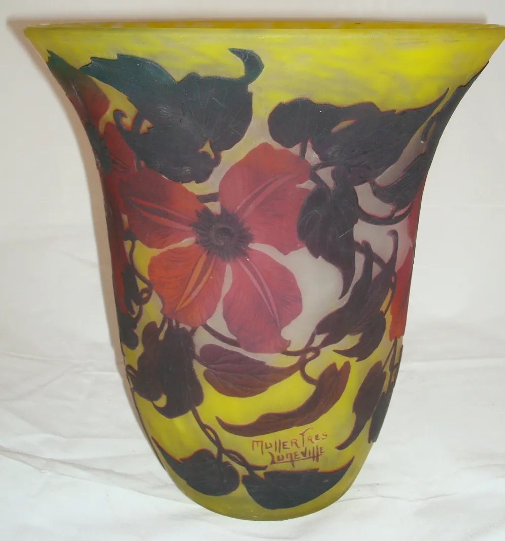 Vaso em forma de flor com detalhes vermelhos sobre fundo amarelo, assinado Muller Fres.