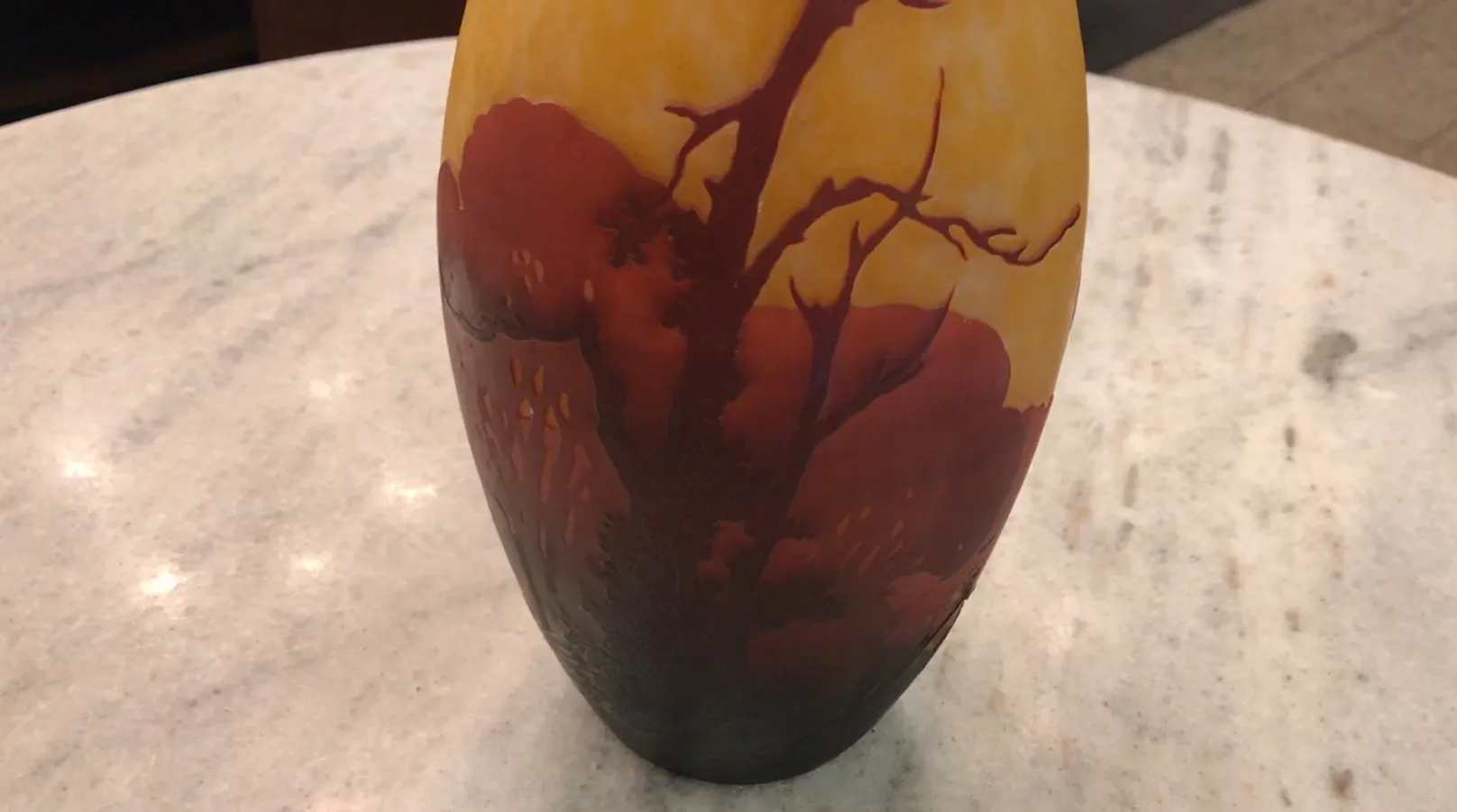 Um elegante vaso antigo com um belo design de paisagem em tons quentes