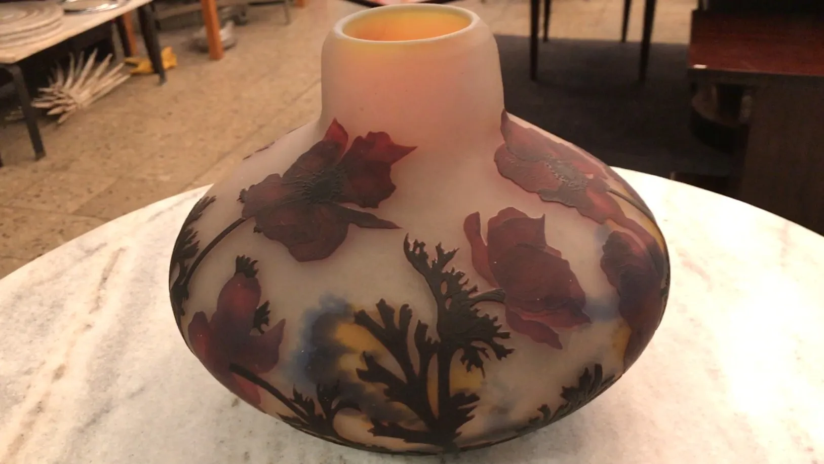 Vidro assinado de Muller Fres com decoração floral em ambiente antigo.