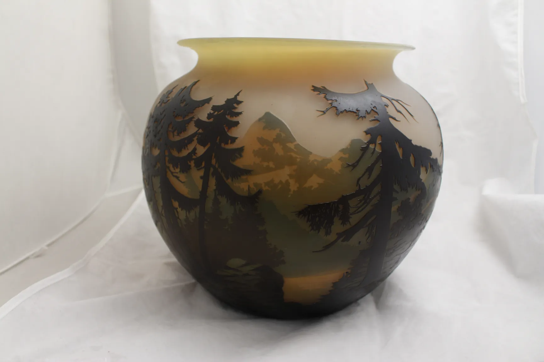 Vaso antigo com design de paisagem e árvores na superfície.