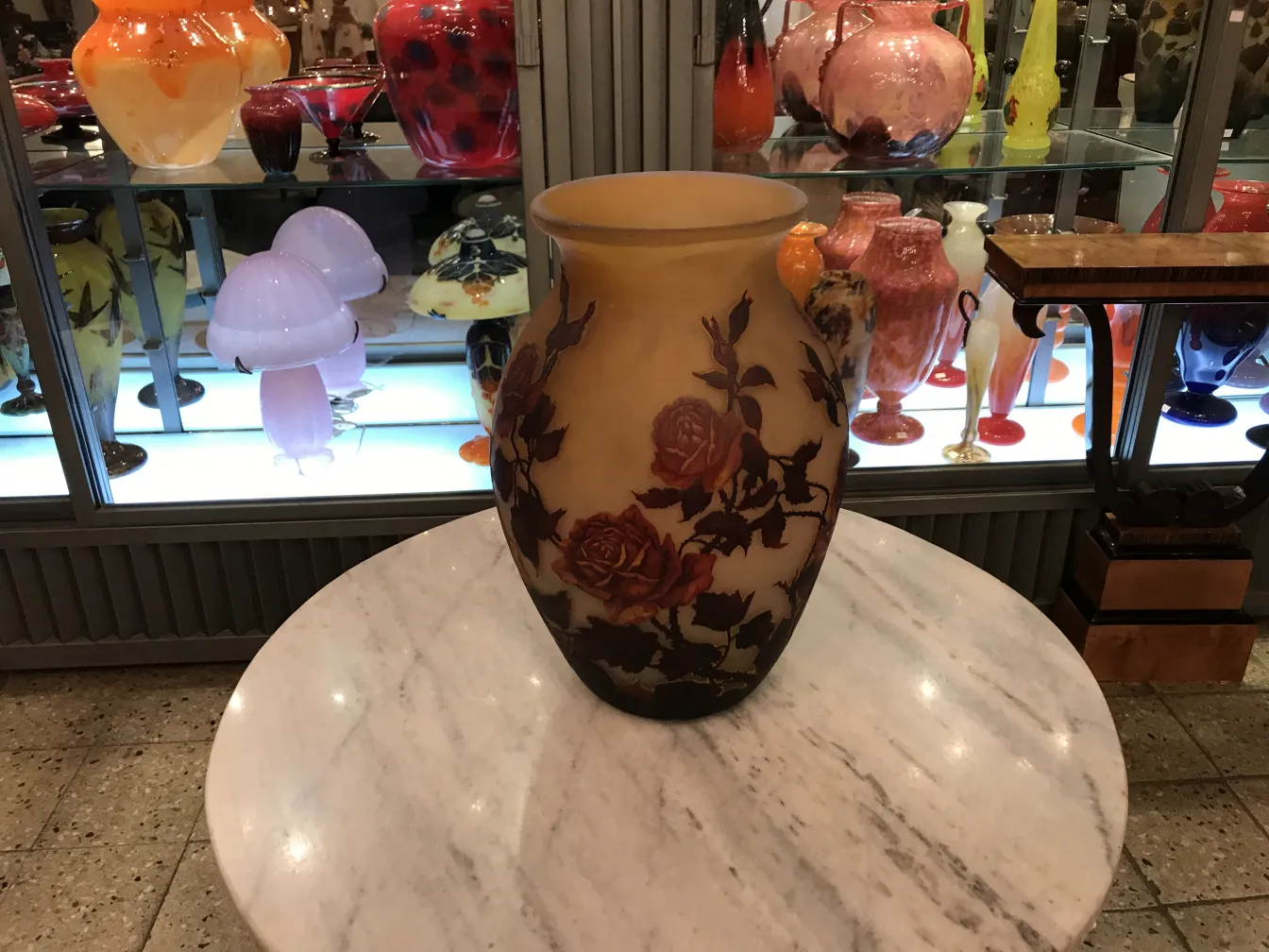Vaso antigo de vidro com design floral, assinado por Muller Fres em um ambiente elegante