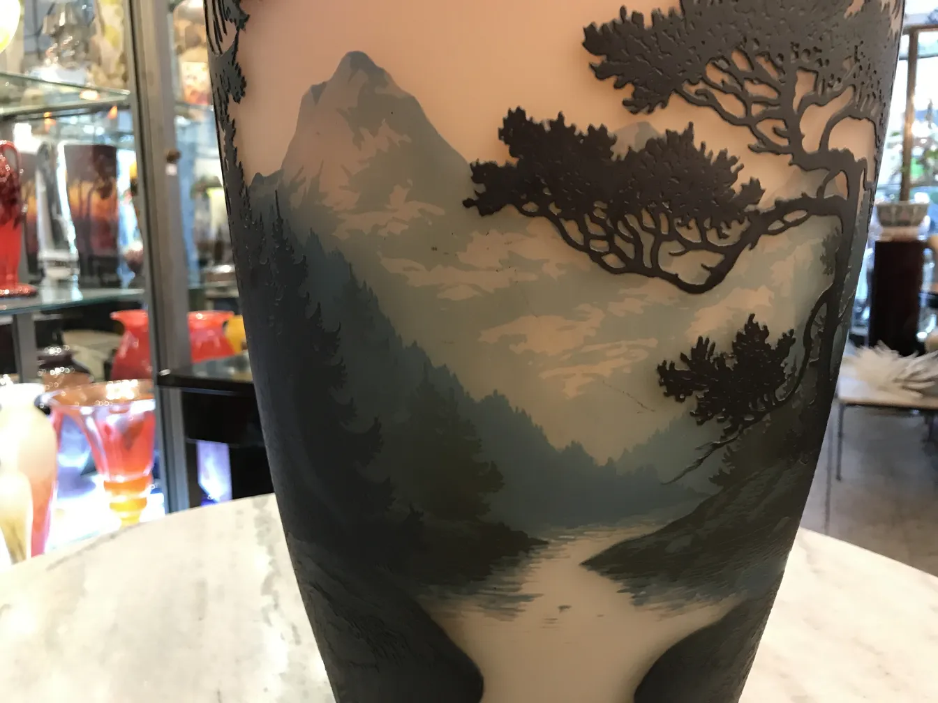 Vidro antigo com paisagem, assinado por Muller Fres, em ambiente decorativo.