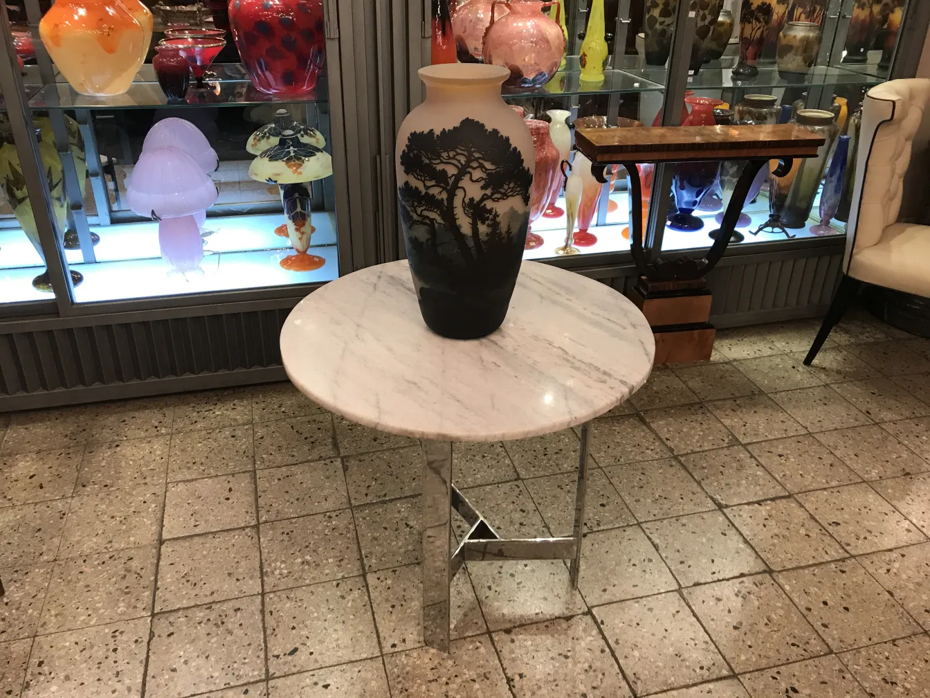 Vaso antigo sobre mesa em meio a antiguidades